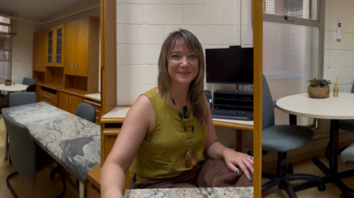 Capa de notícia formada por três fotografias verticais. Da esquerda para a direita: fotografia que mostra plano geral de uma sala com mesas, cadeiras, armários; fotografia que mostra uma mulher sentada e sorrindo levemente para a câmera e fotografia que focaliza uma mesa da sala da primeira fotografia. Fim da descrição.